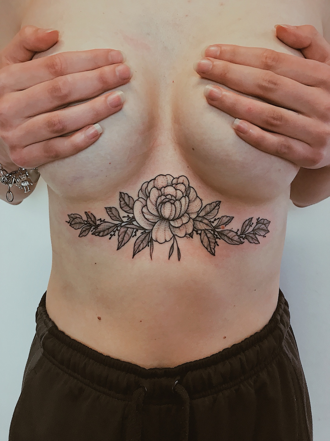 Composizione floreale tatuata sotto il petto