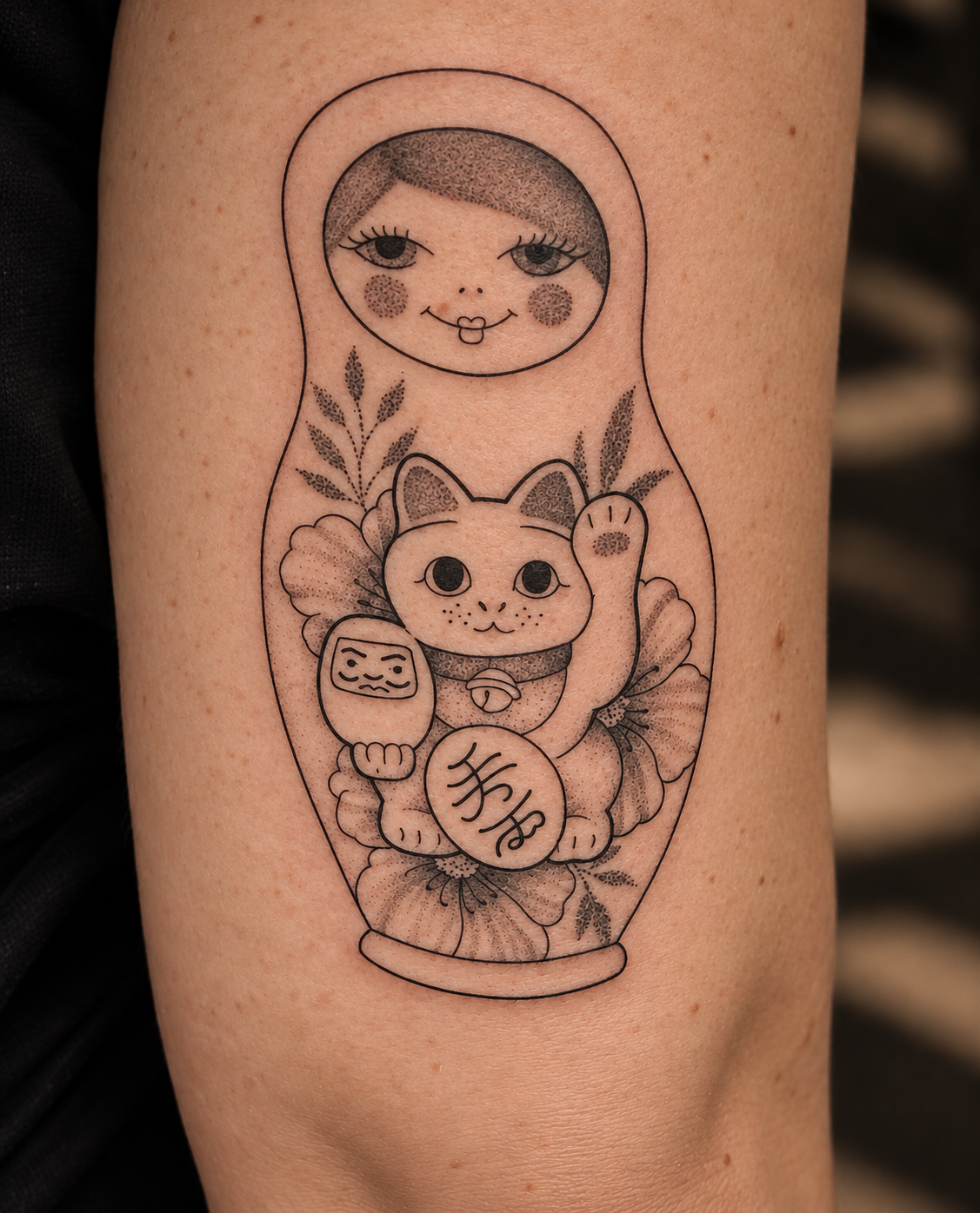 Tatuaggio di una matrioska assembrata ad altri elementi 